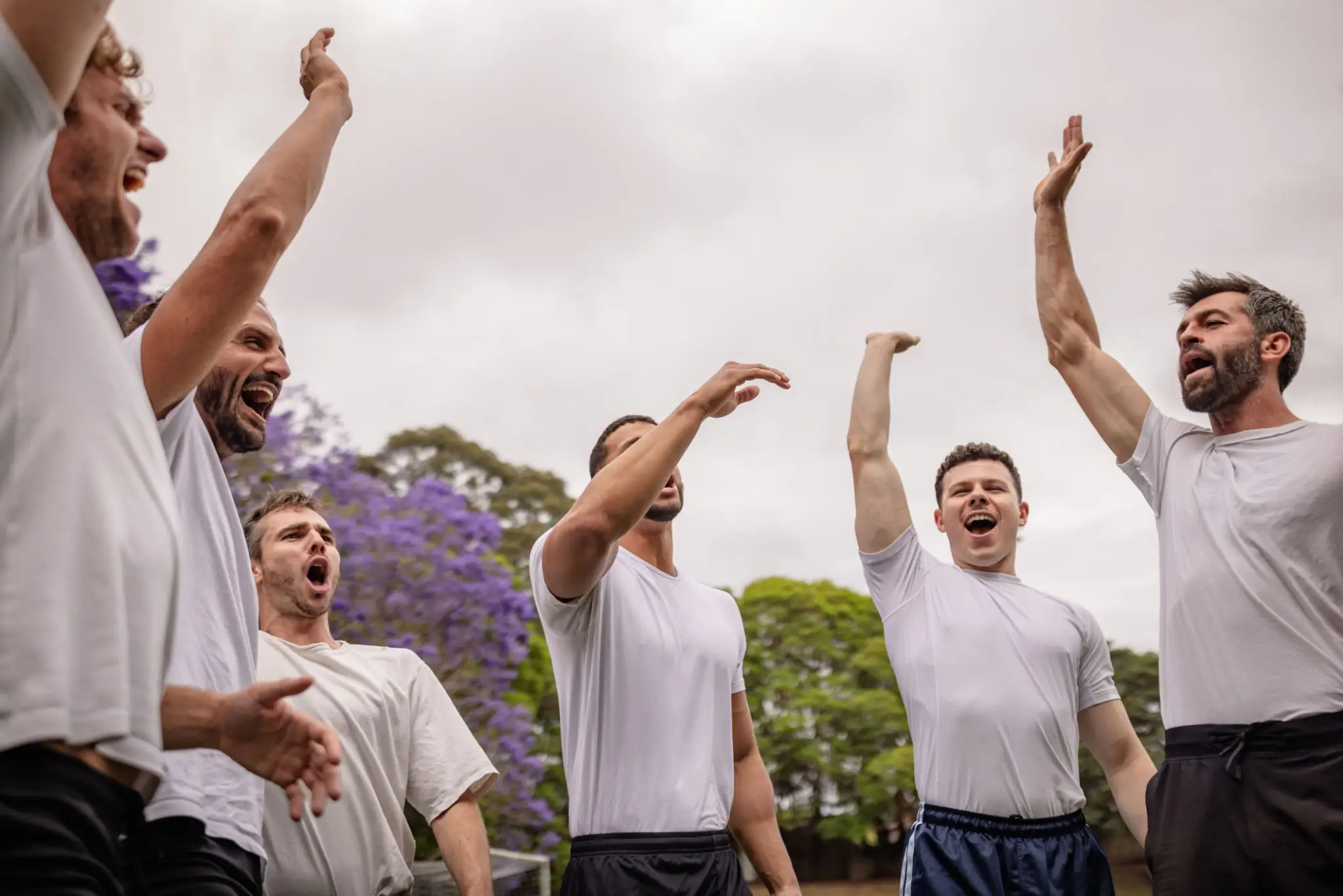 Group of men cheering outdoors
