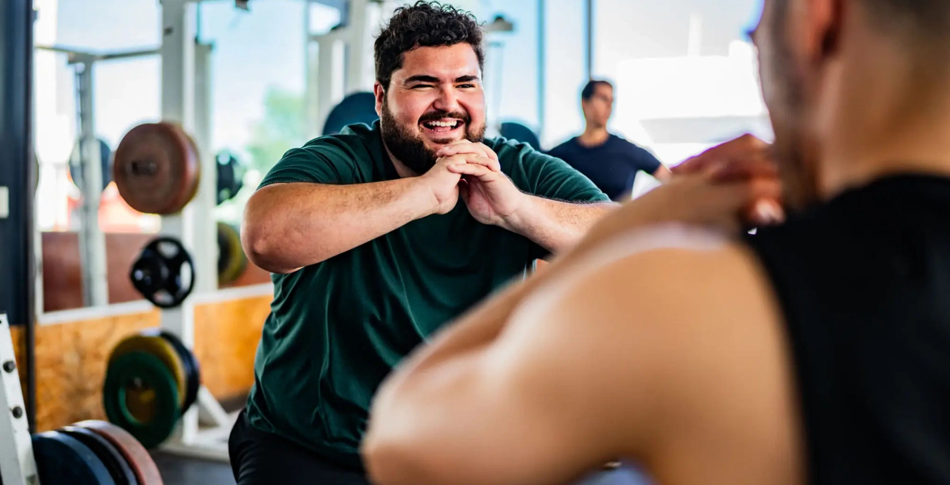 Smiling man squatting in gym