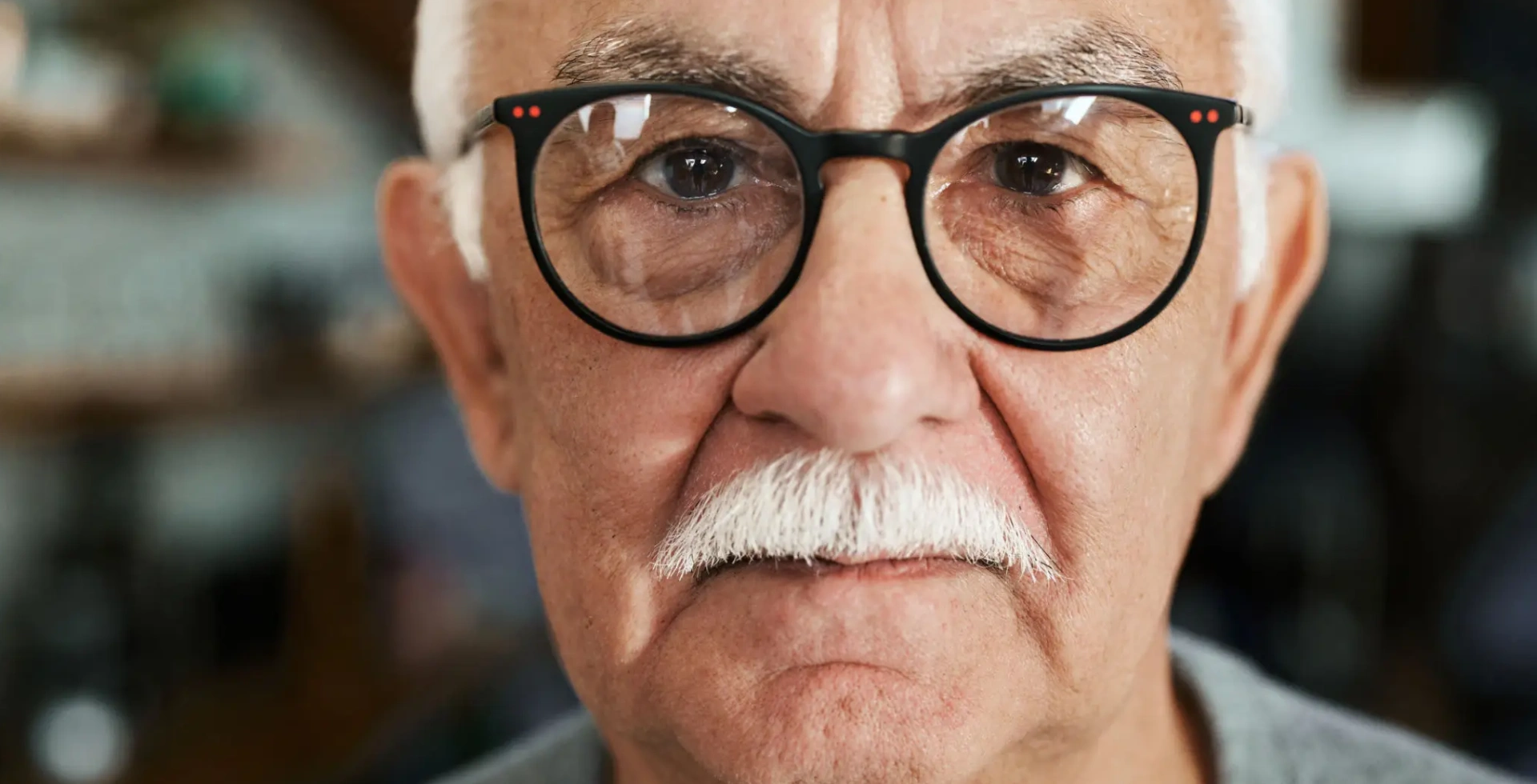 Elderly man wearing glasses and white mustache