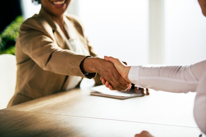 Business handshake between two professionals at table