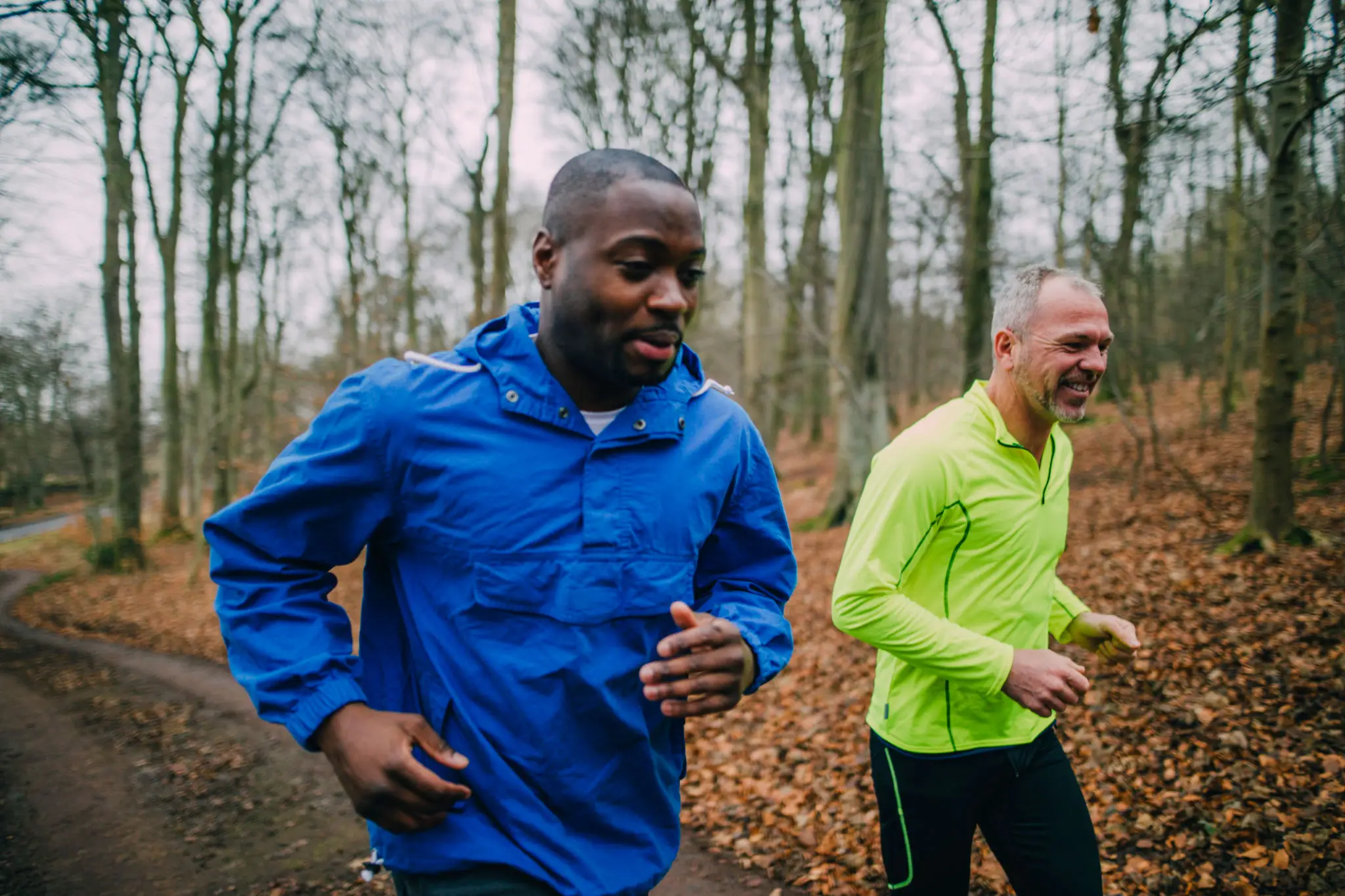 Two people running on forest trail