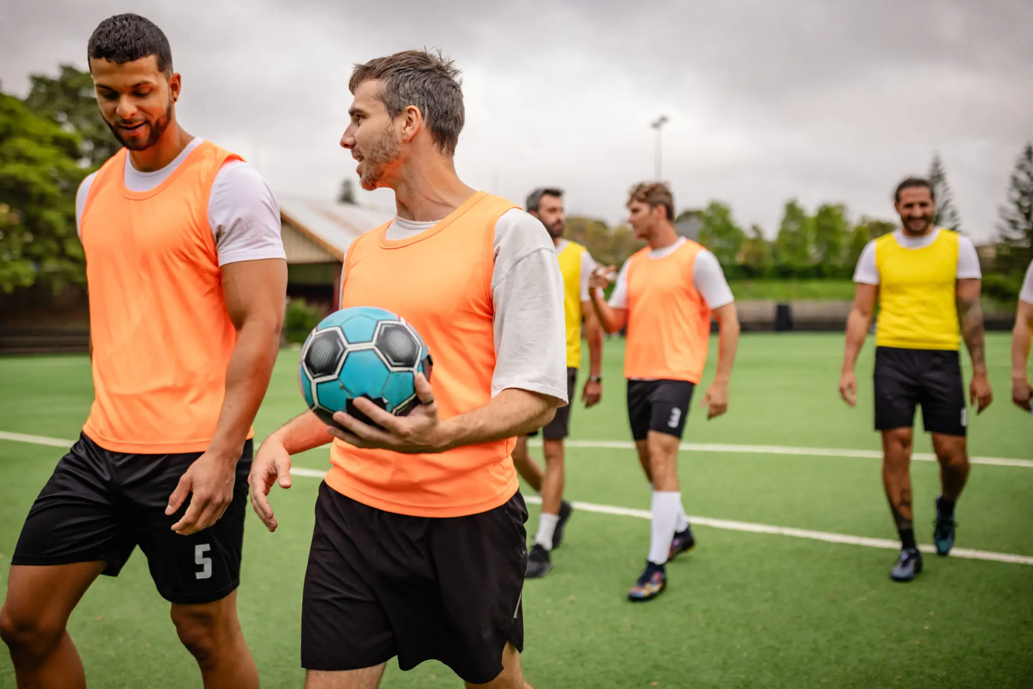 Soccer players in training bibs on field