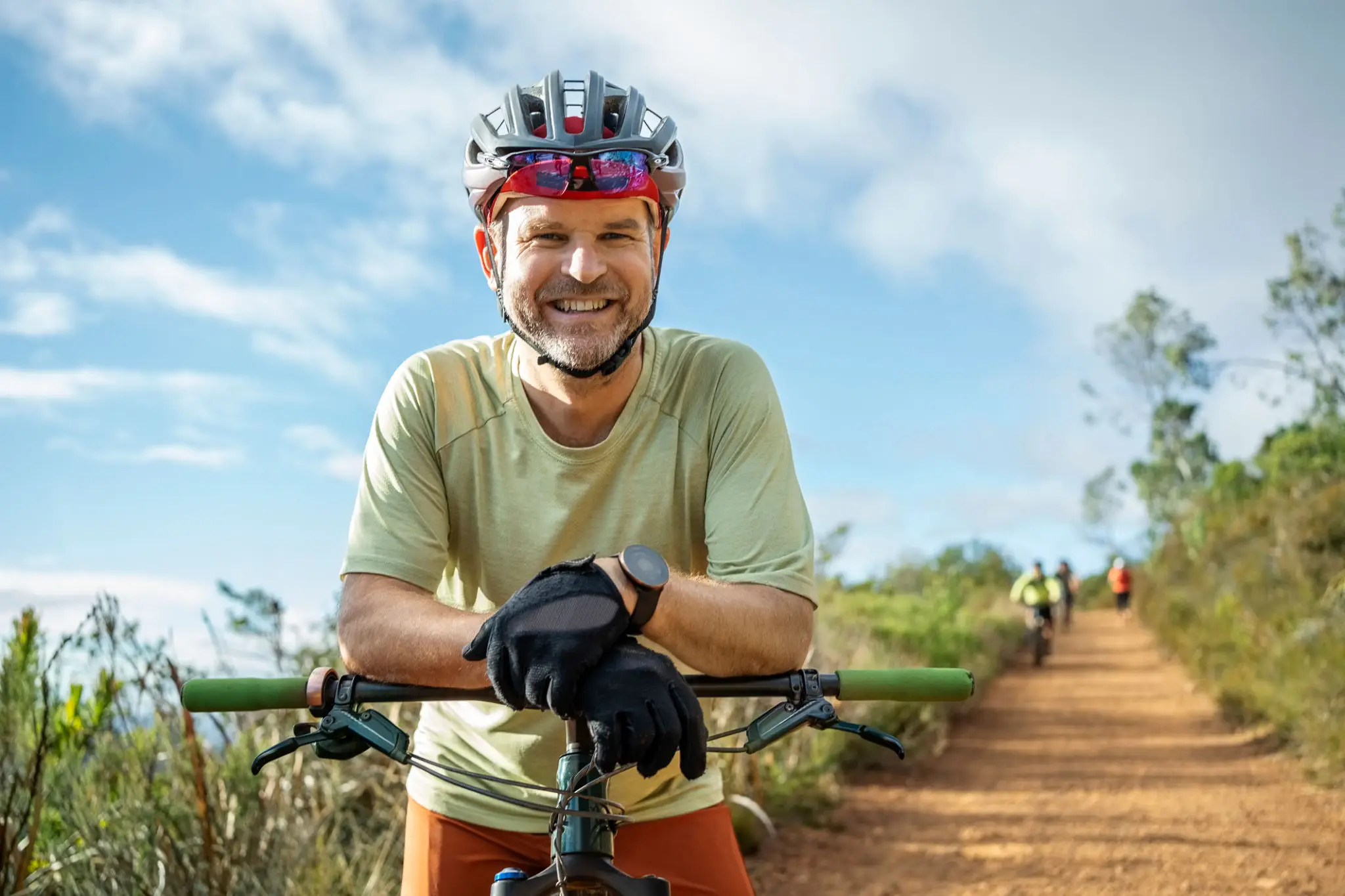Smiling cyclist leaning on mountain bike