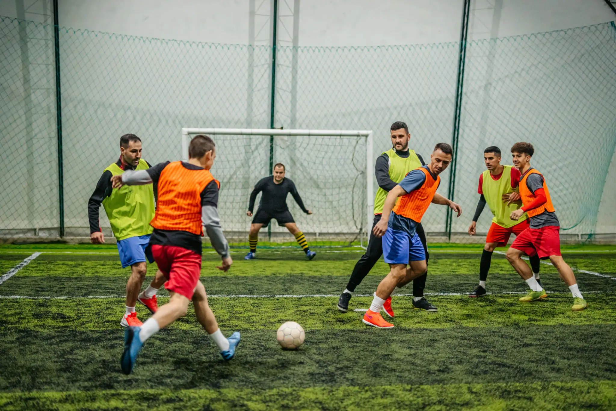 Players contesting ball in indoor soccer match