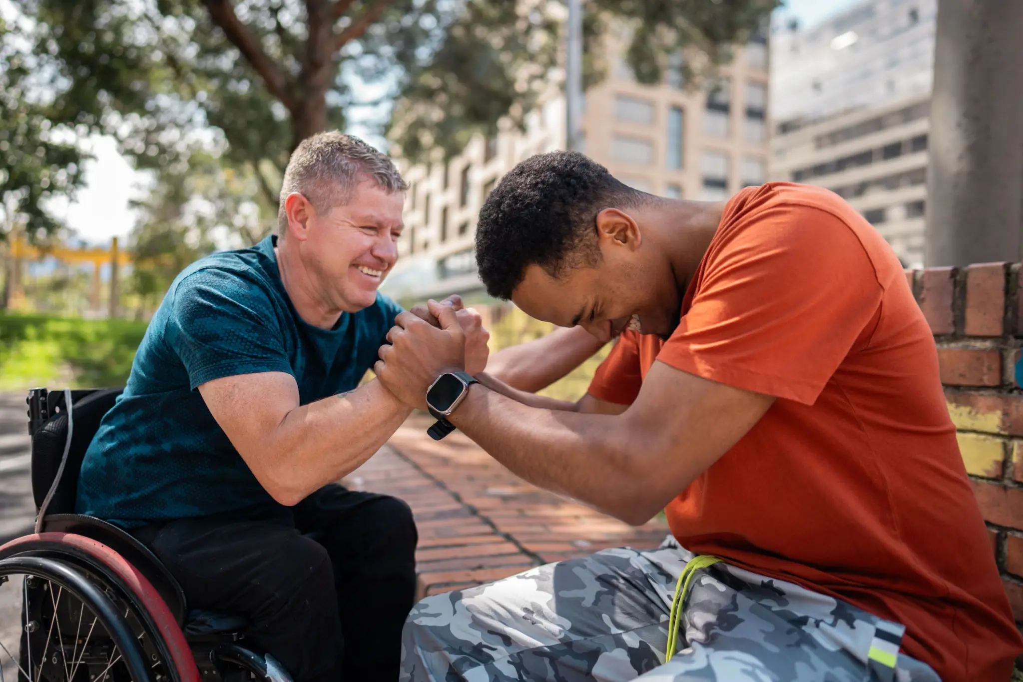 Two men smiling and clasping hands outdoors