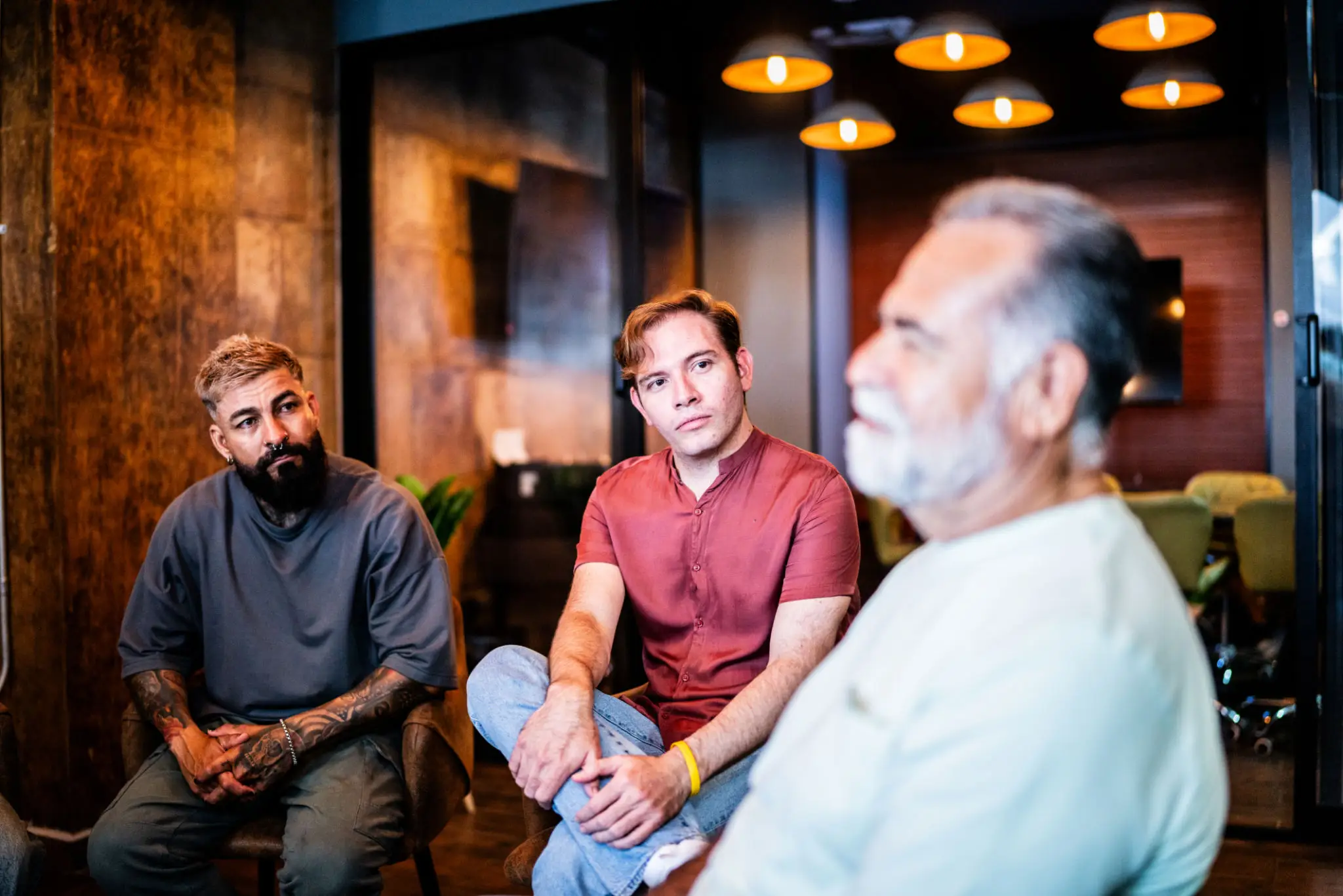 Three men conversing in modern lounge