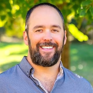 Smiling bearded man in park setting