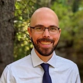 Smiling bald man wearing glasses and tie