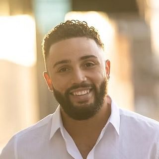 Smiling bearded man in white shirt