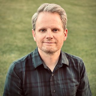 Smiling man in plaid shirt outdoors