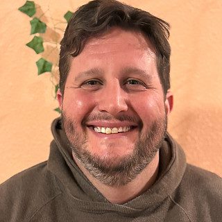 Smiling bearded man wearing brown hoodie