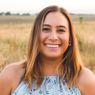 Smiling woman standing in grassy field