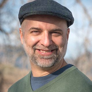 Smiling bearded man wearing flat cap