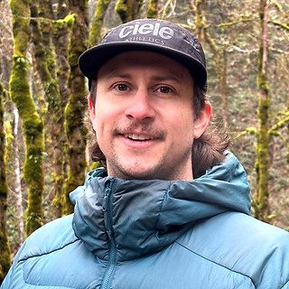Man wearing blue jacket and cap outdoors