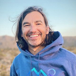 Smiling man outdoors wearing blue hoodie