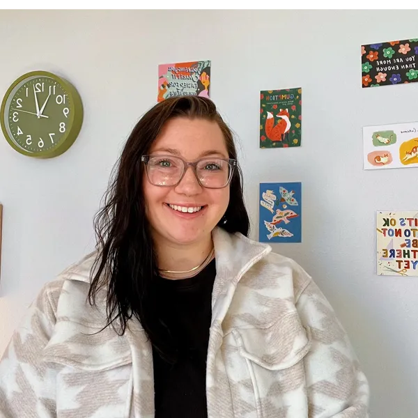 Smiling person with glasses in decorated room