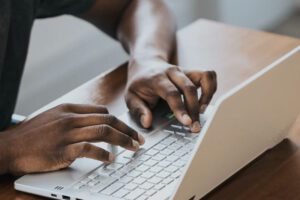Hands typing on a laptop keyboard