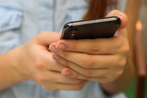 Person holding smartphone, typing a message