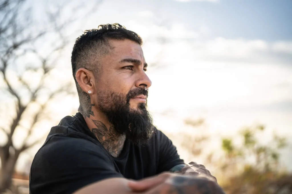 Bearded tattooed man gazing into distance