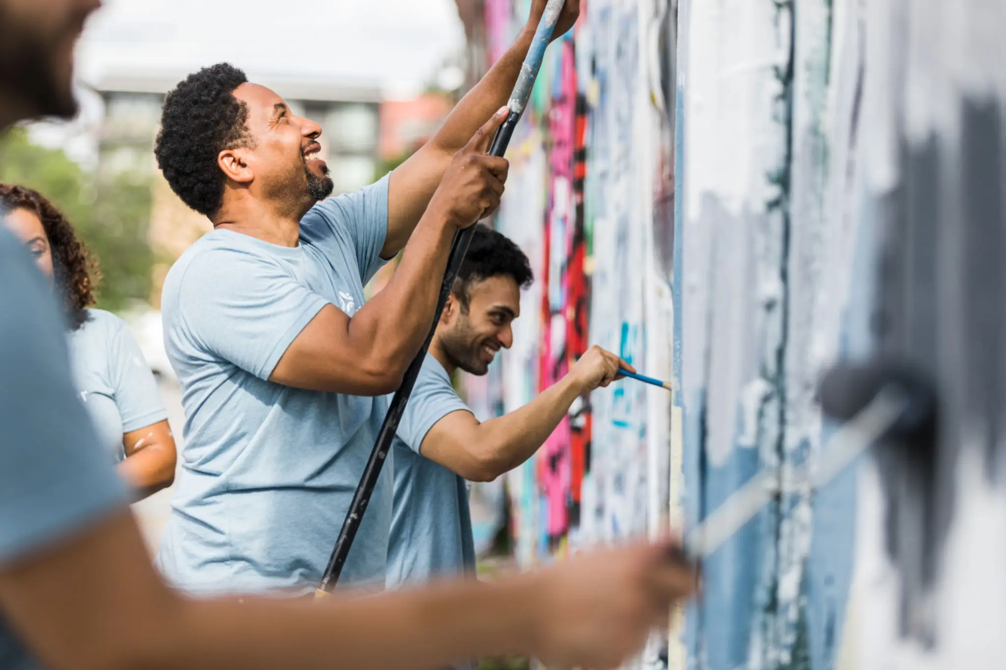 Volunteers painting outdoor mural together