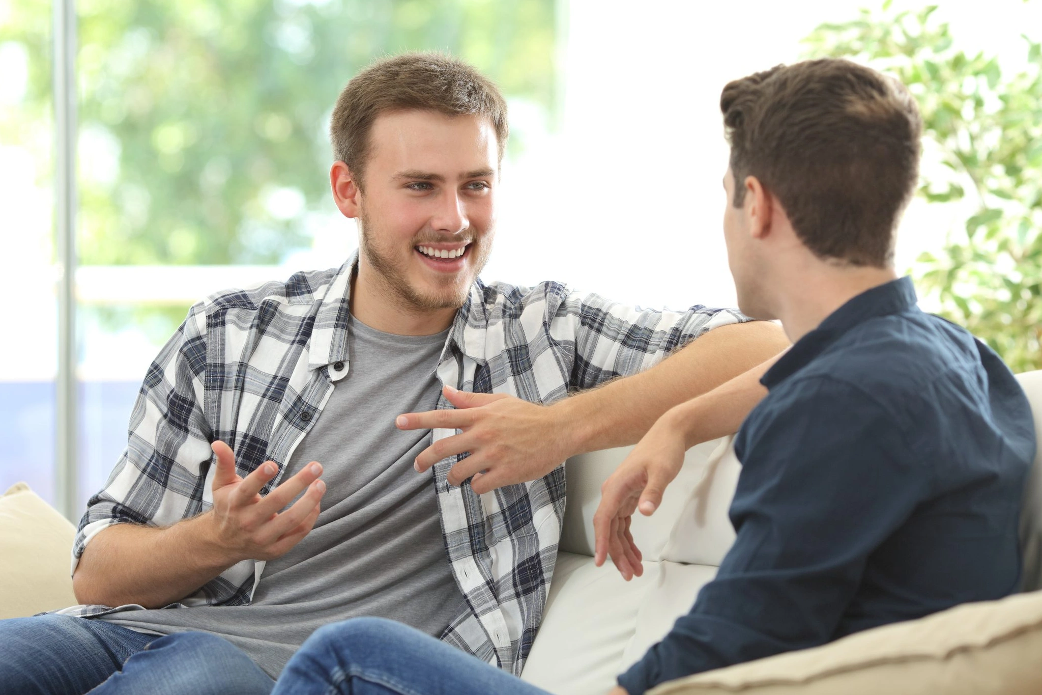 Two young men chatting on couch