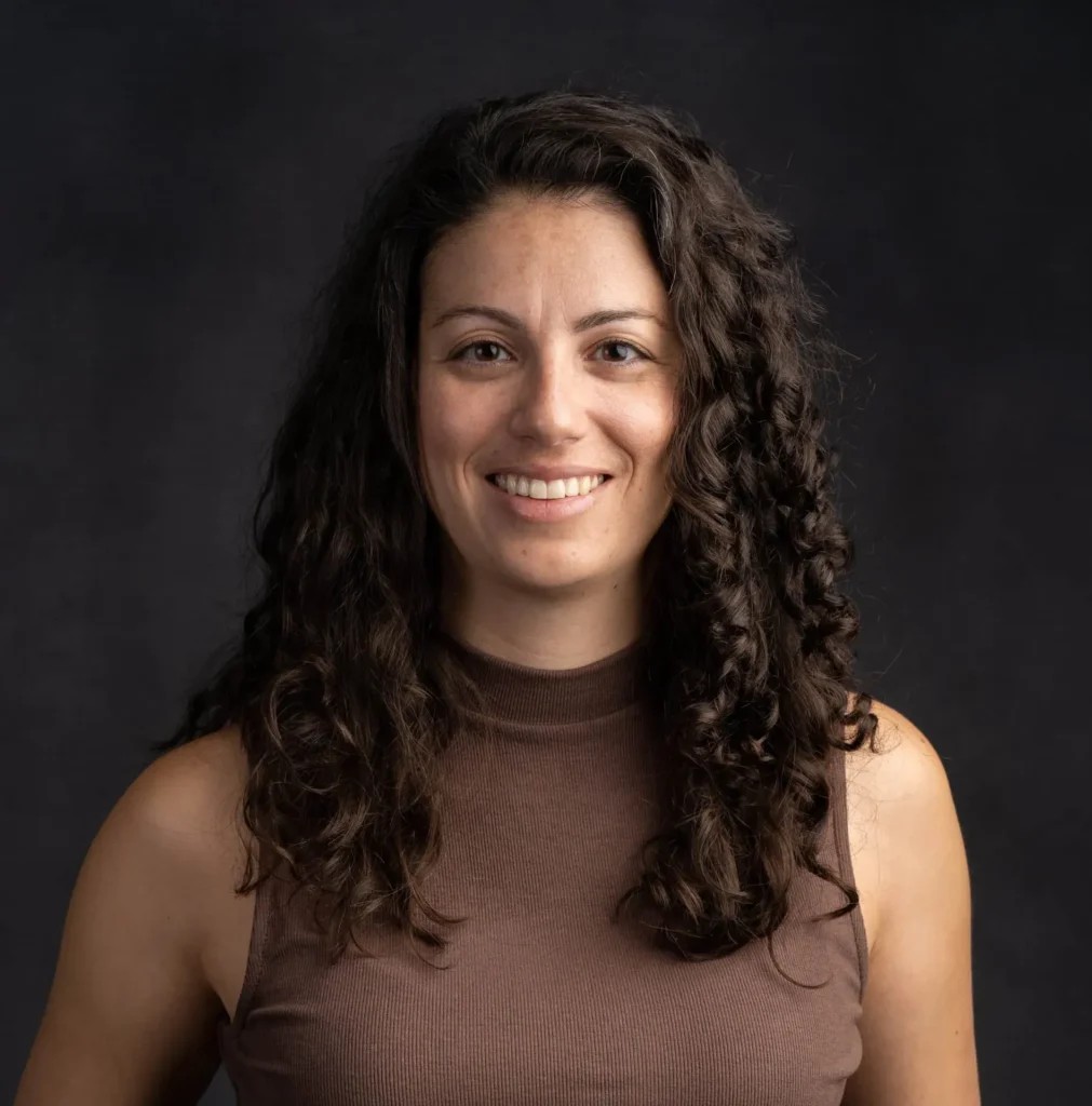 Smiling woman with curly hair in brown top